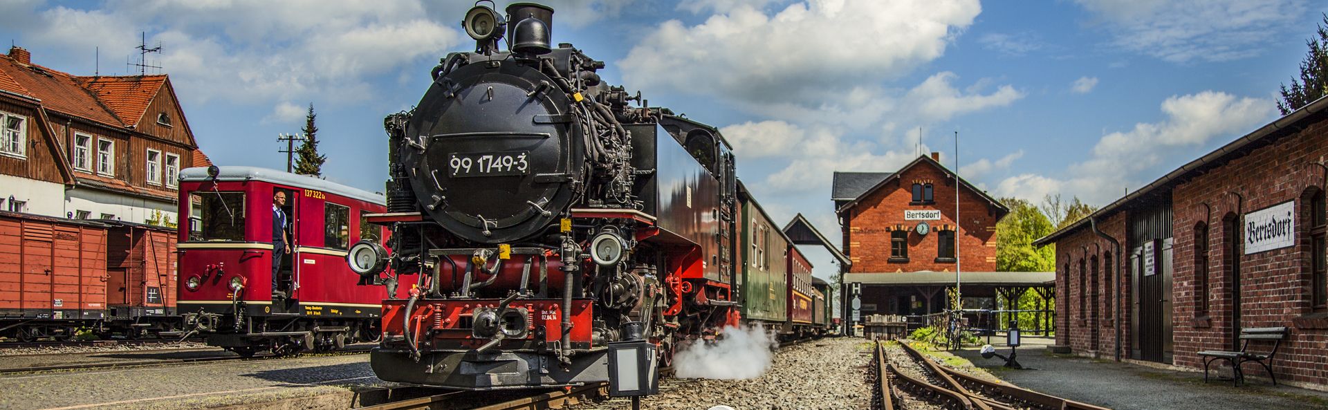 Bahnhof Bertsdorf an der Zittauer Schmalspurbahn mit historischem Triebwagen und Dampfzug